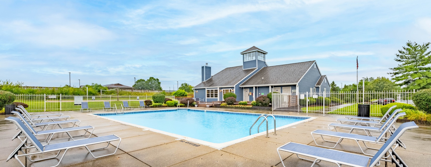 Pool with chairs and building in background
