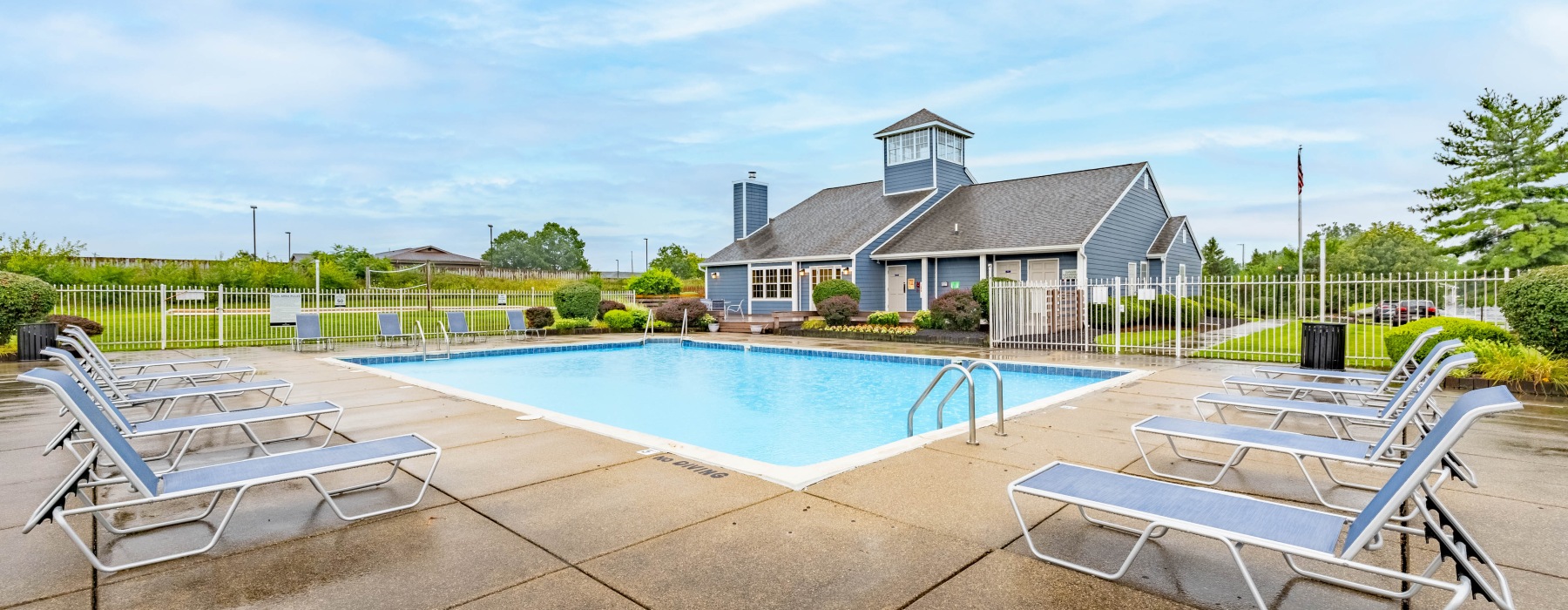 Pool with chairs and building in background