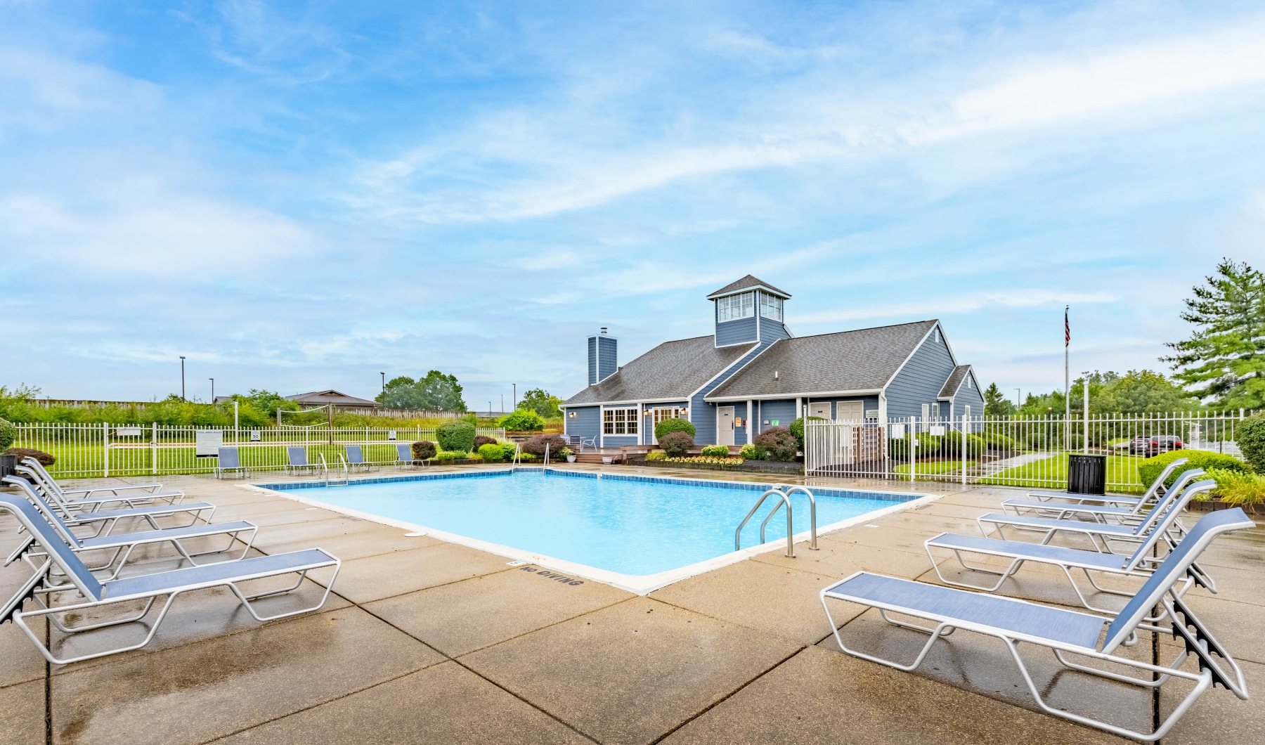 Pool with chairs and building in background